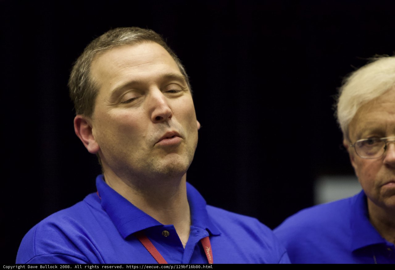 Two Men in Blue Shirts Engage in a Serious Discussion