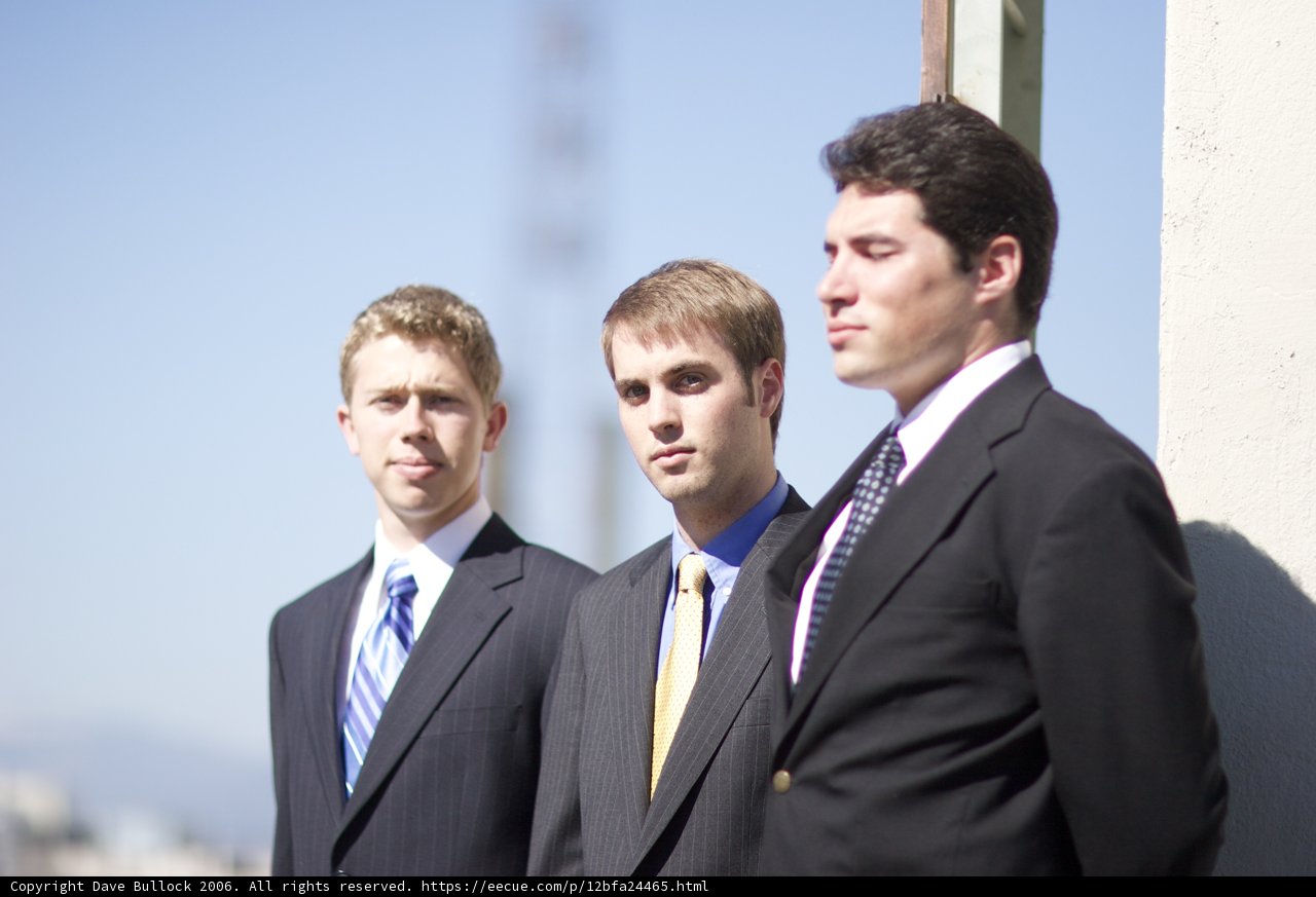 Three Men in Suits Under a Blue Sky