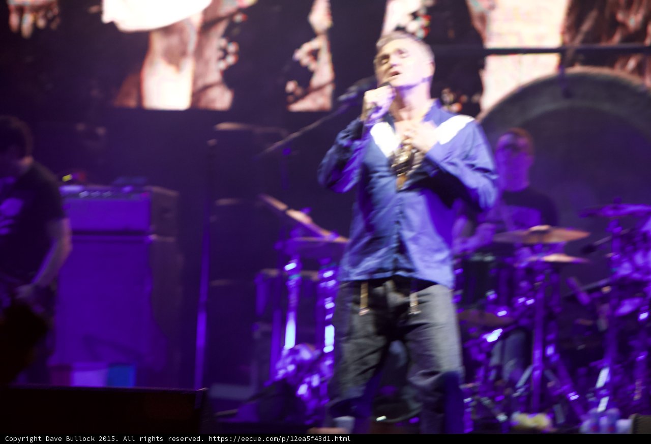 Morrissey Full Body Hands At Chest Blue Shirt Drummer Capitol Tee Bassist Gong Purple Lighting Smiths Screen