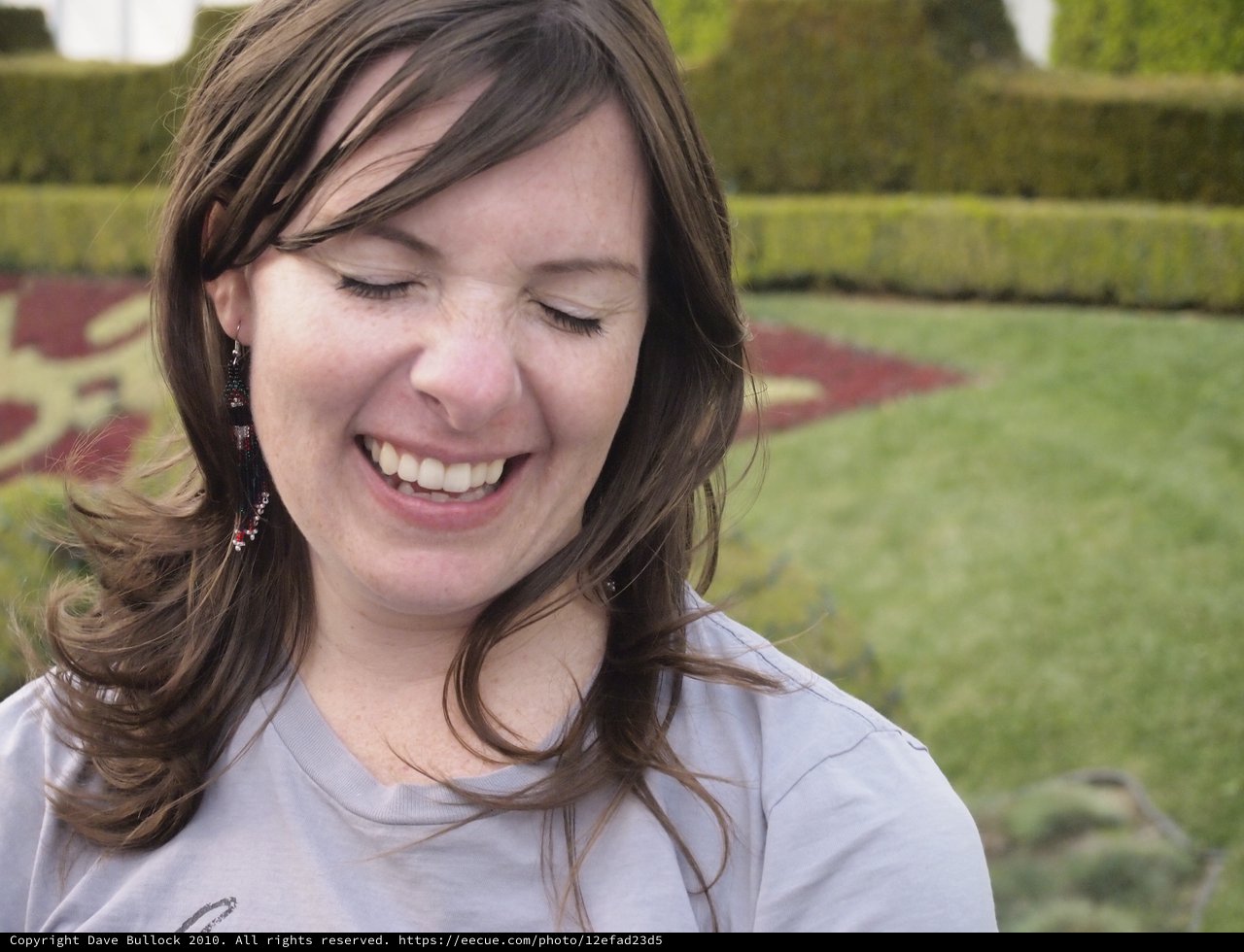 Woman Laughing Joyfully in a Formal Garden