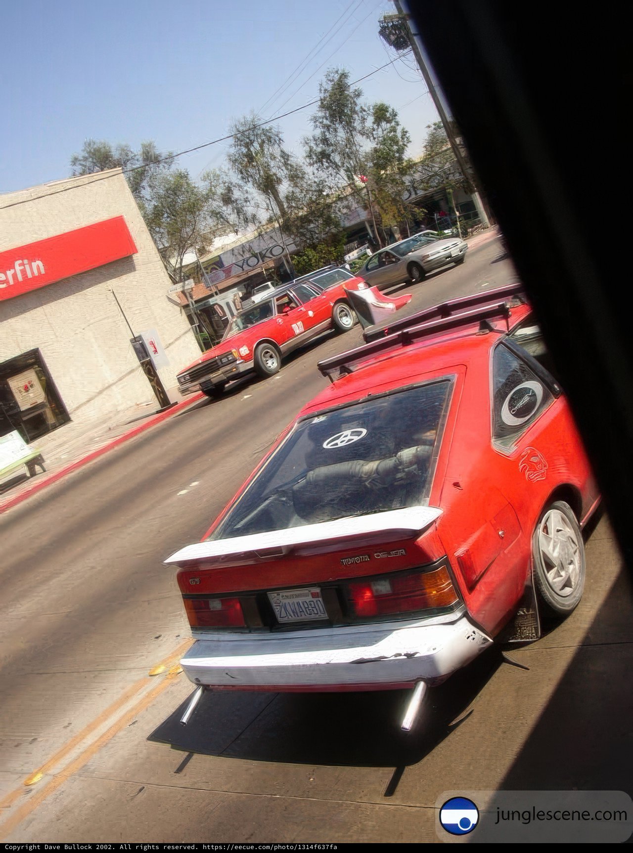 Red sports car parked at a gas station