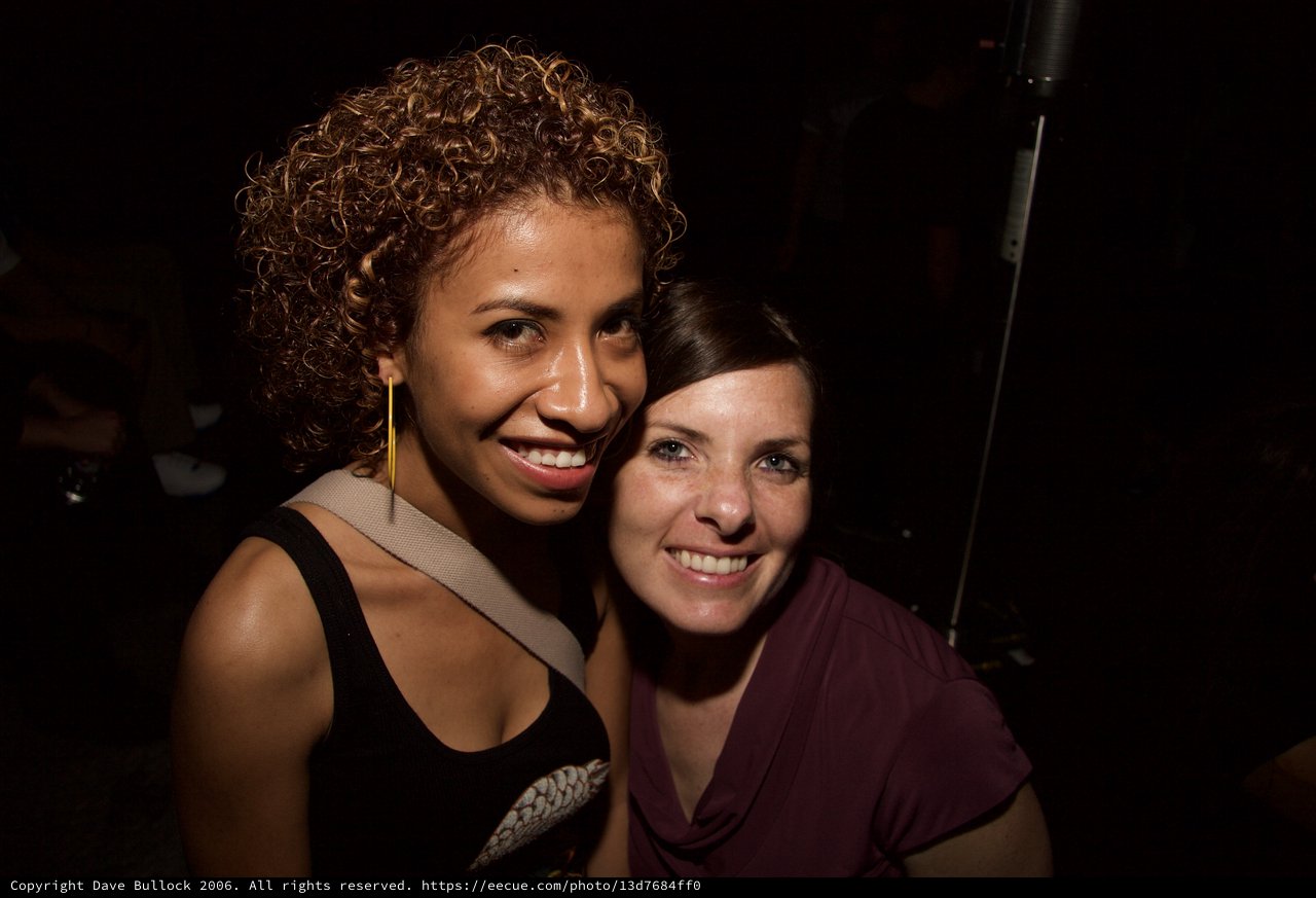 Two Friends Smiling Together at a Nightclub Event