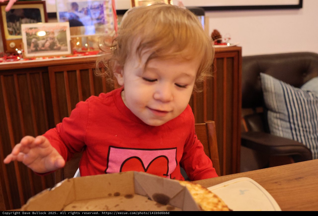 Toddler Enjoying Pizza at Christmas Dinner