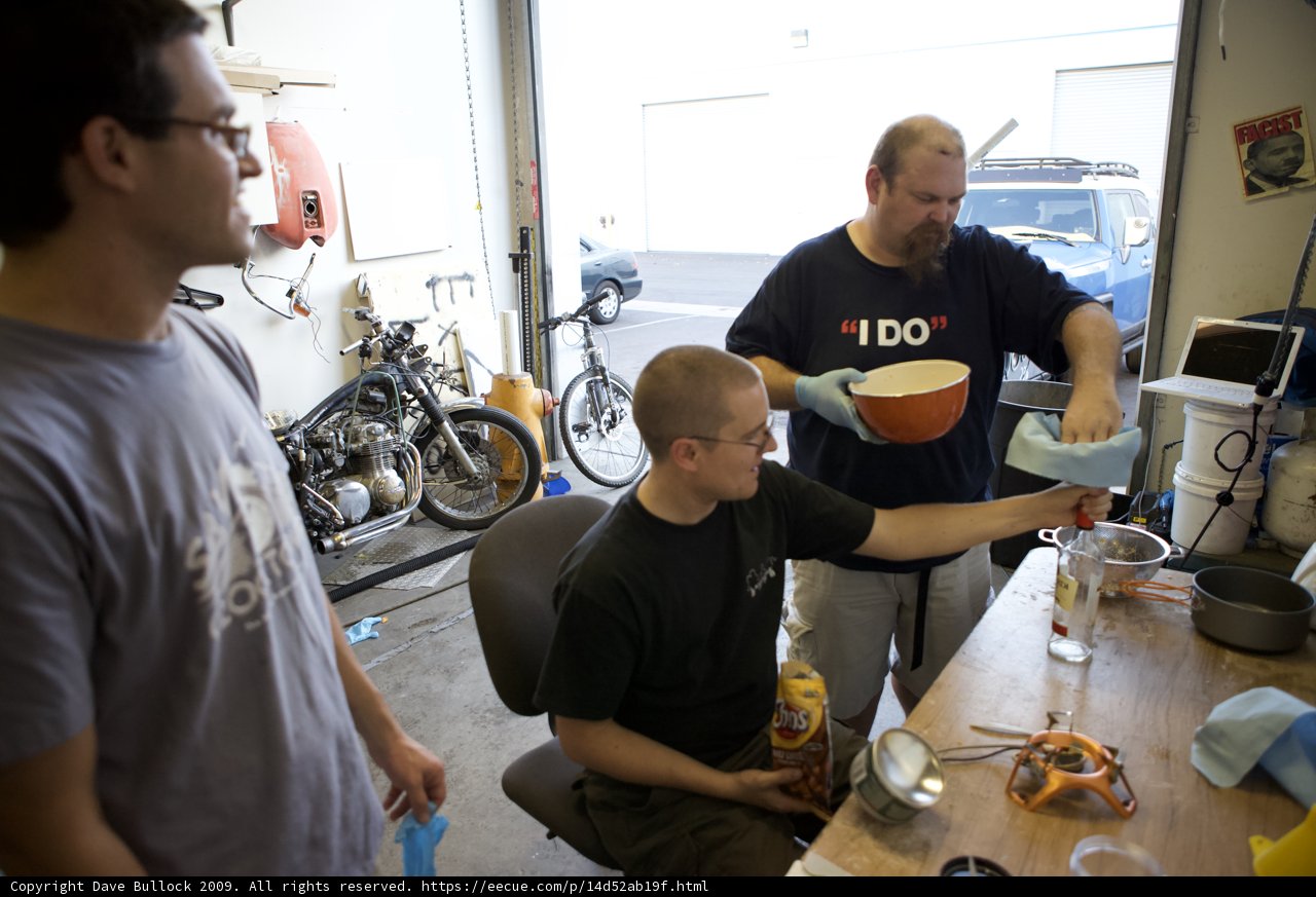 Grey Shirted Man with Bicycle in Manufacturing Shop