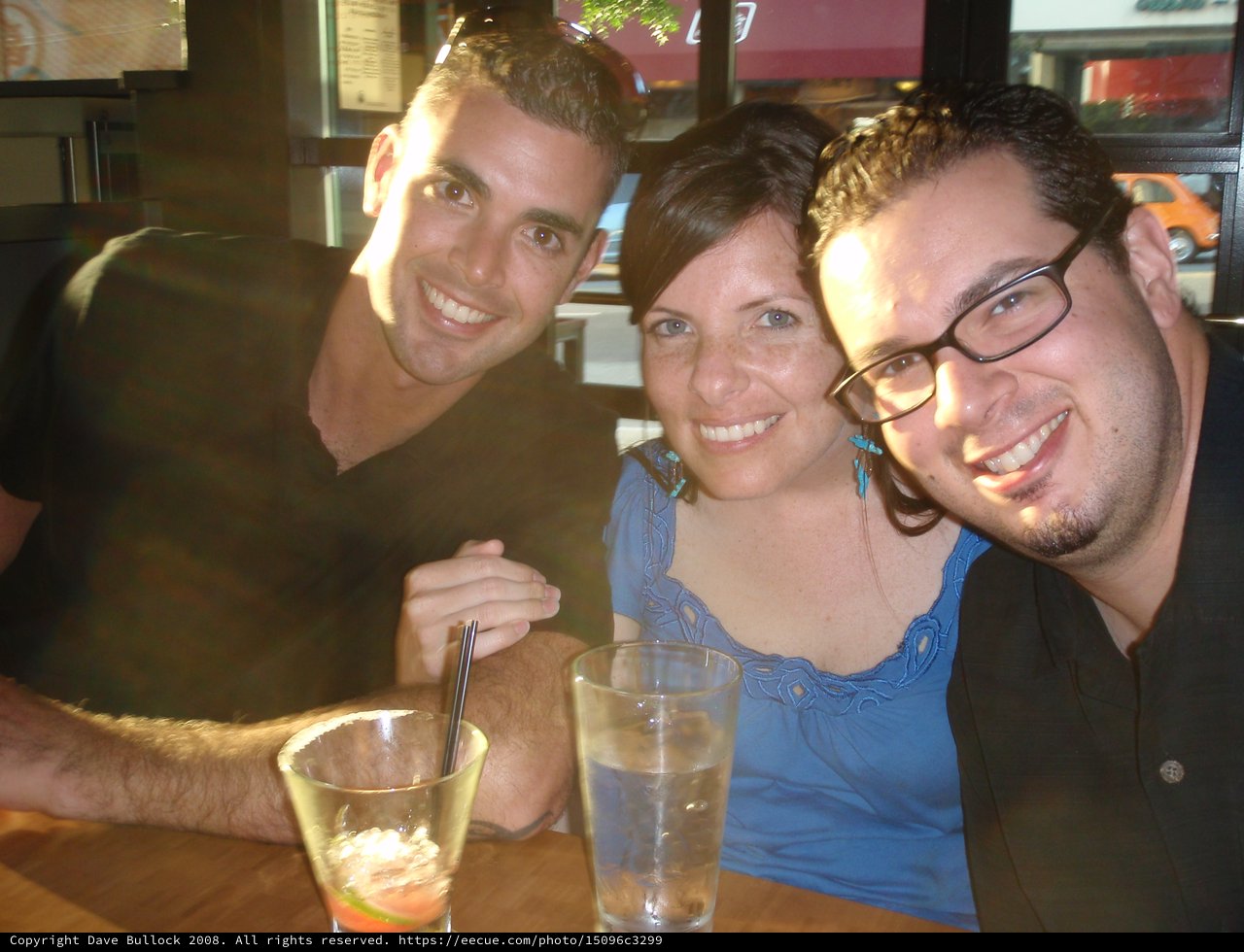 Three Friends Smiling Together at Restaurant Table