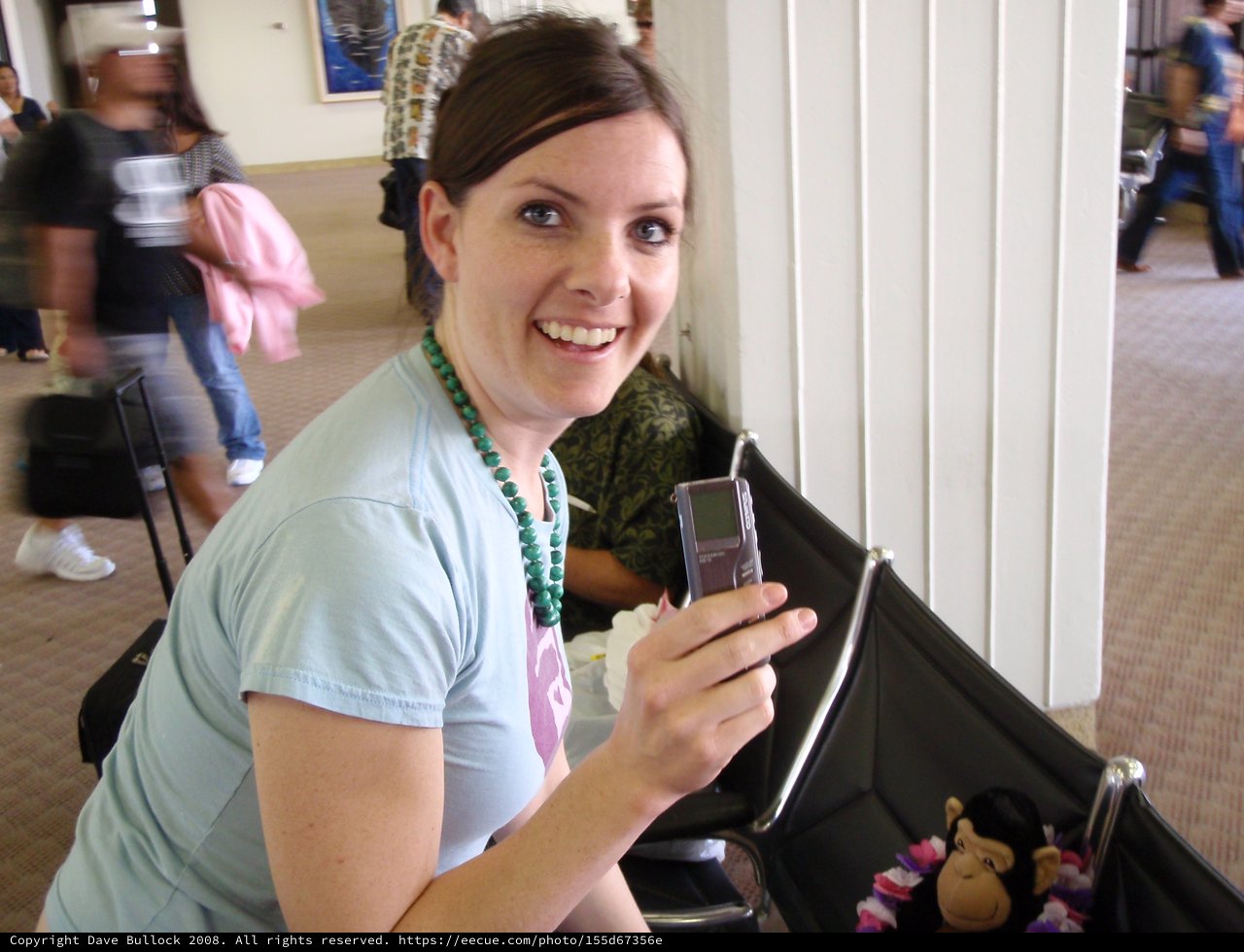 Smiling Woman Shows Off Phone at Hawaiian Airport