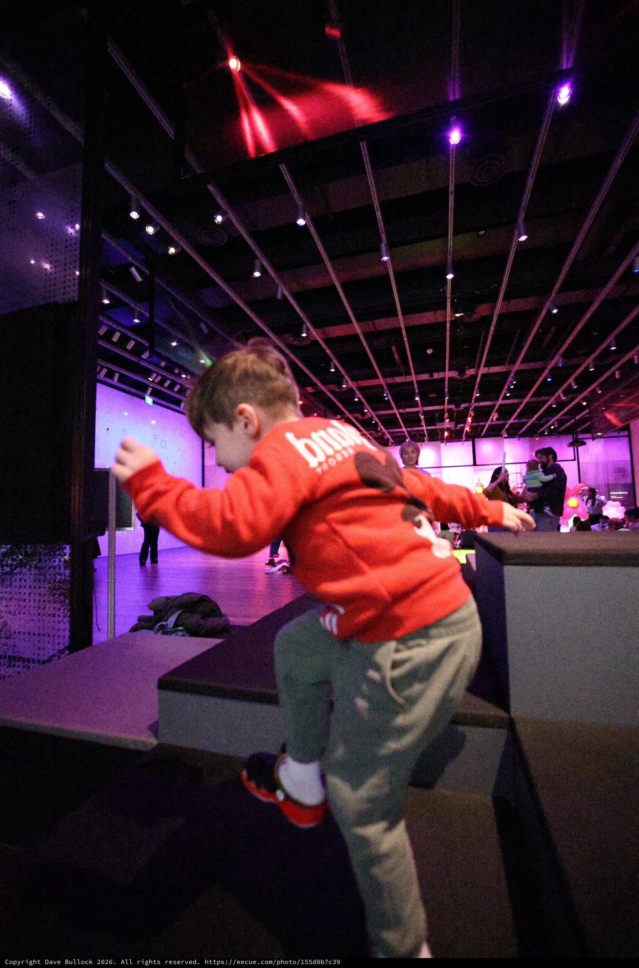 Child Dancing at Purple-Lit Baby Rave Museum Event