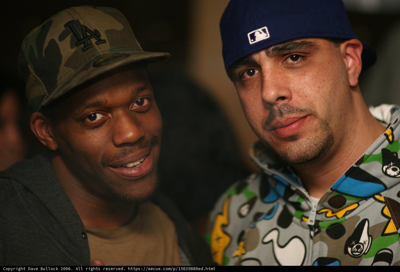 Two men with baseball caps pose for the camera