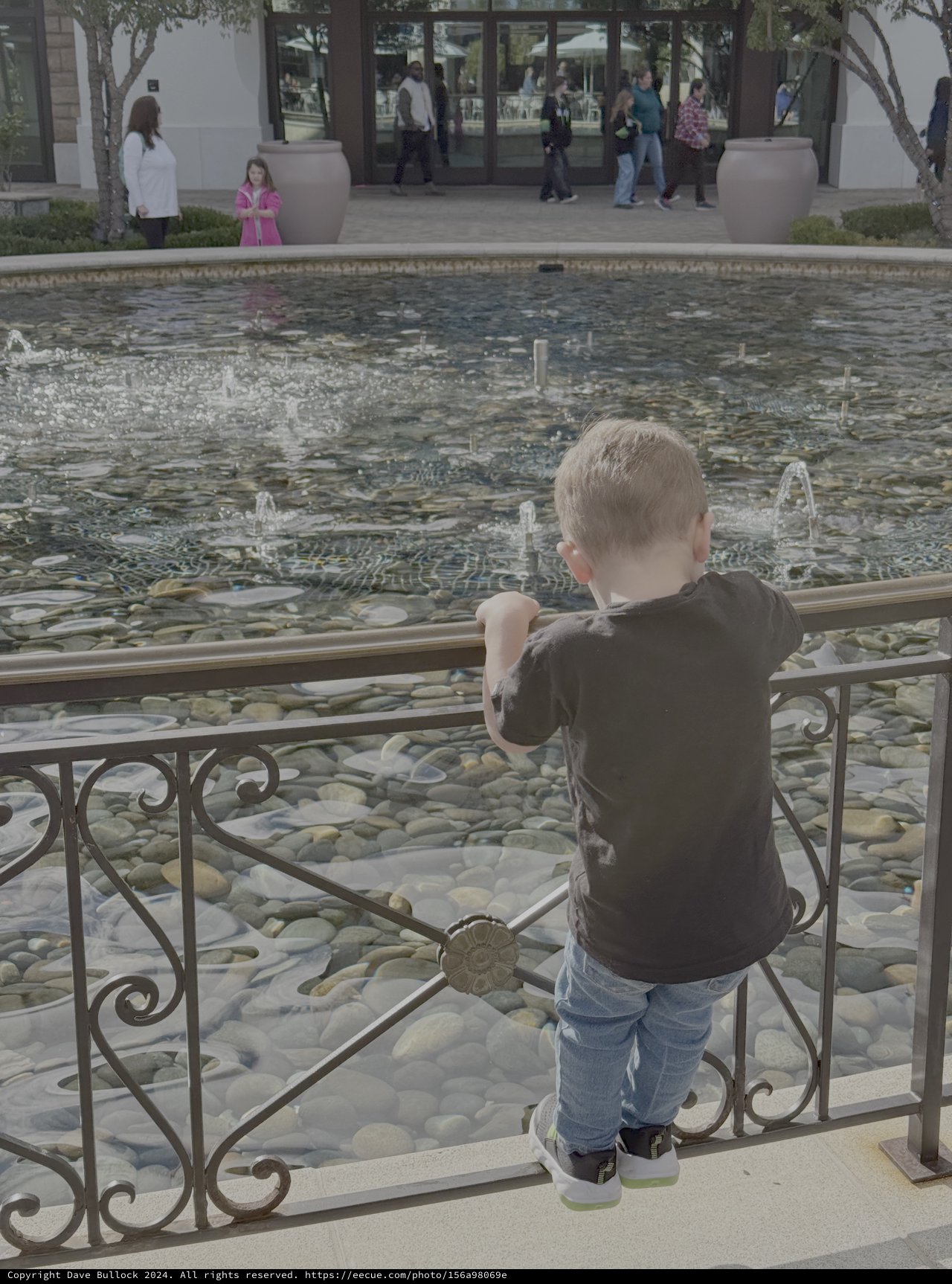 Child Watching Fountain at Public Plaza