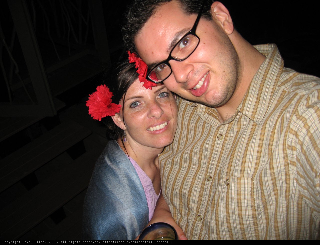 Couple Smiling Together with Red Flowers at Night