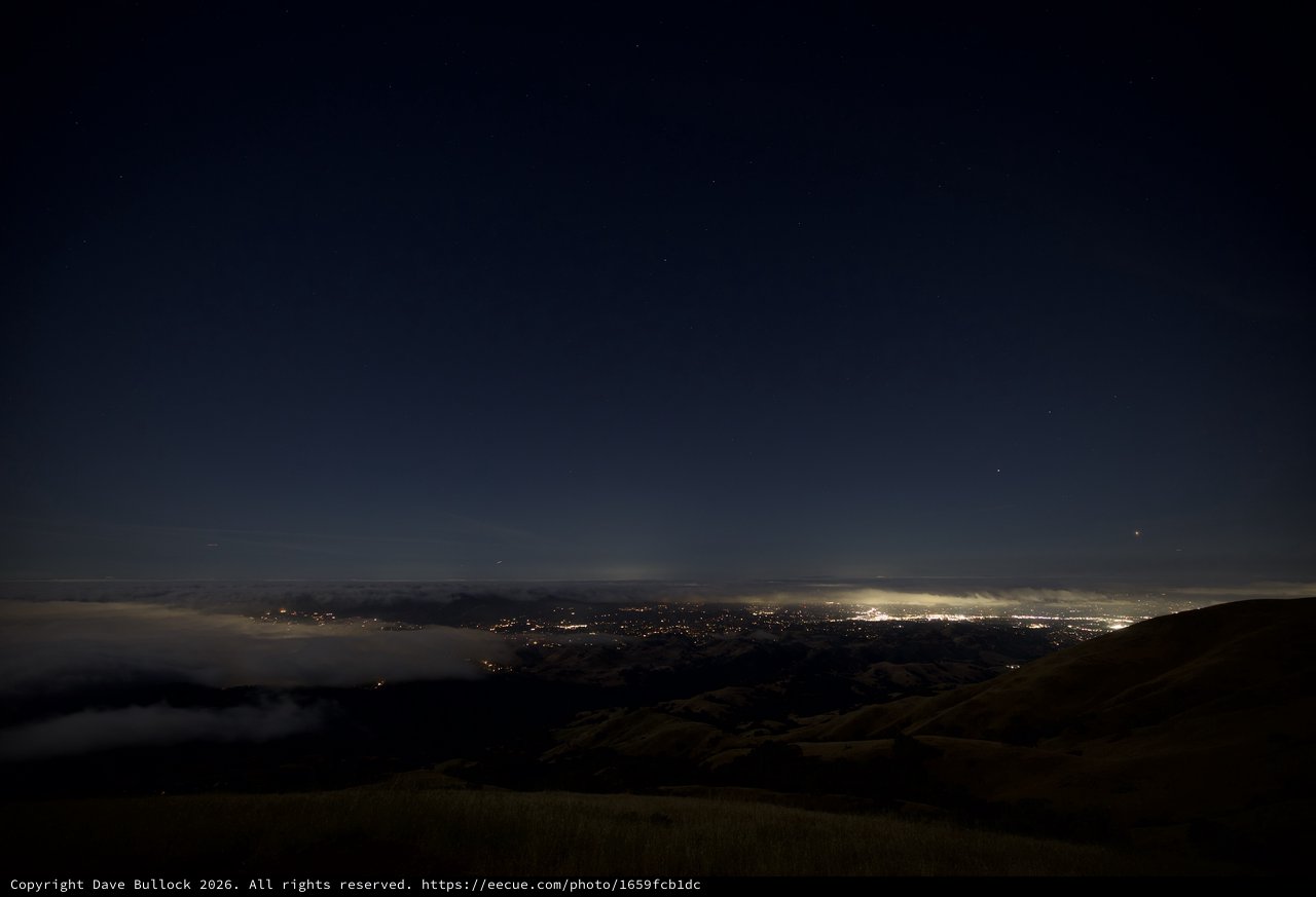 City Lights Glowing Beneath a Sea of Fog