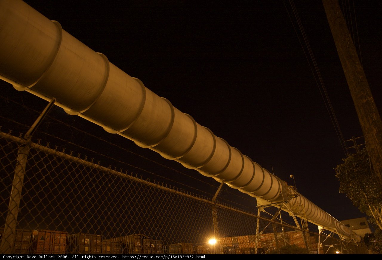 Towering Pipeline and Fence at Night