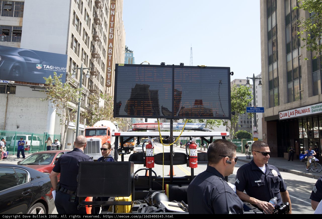 Police Officers Monitor Electronic Sign at May Day Rally