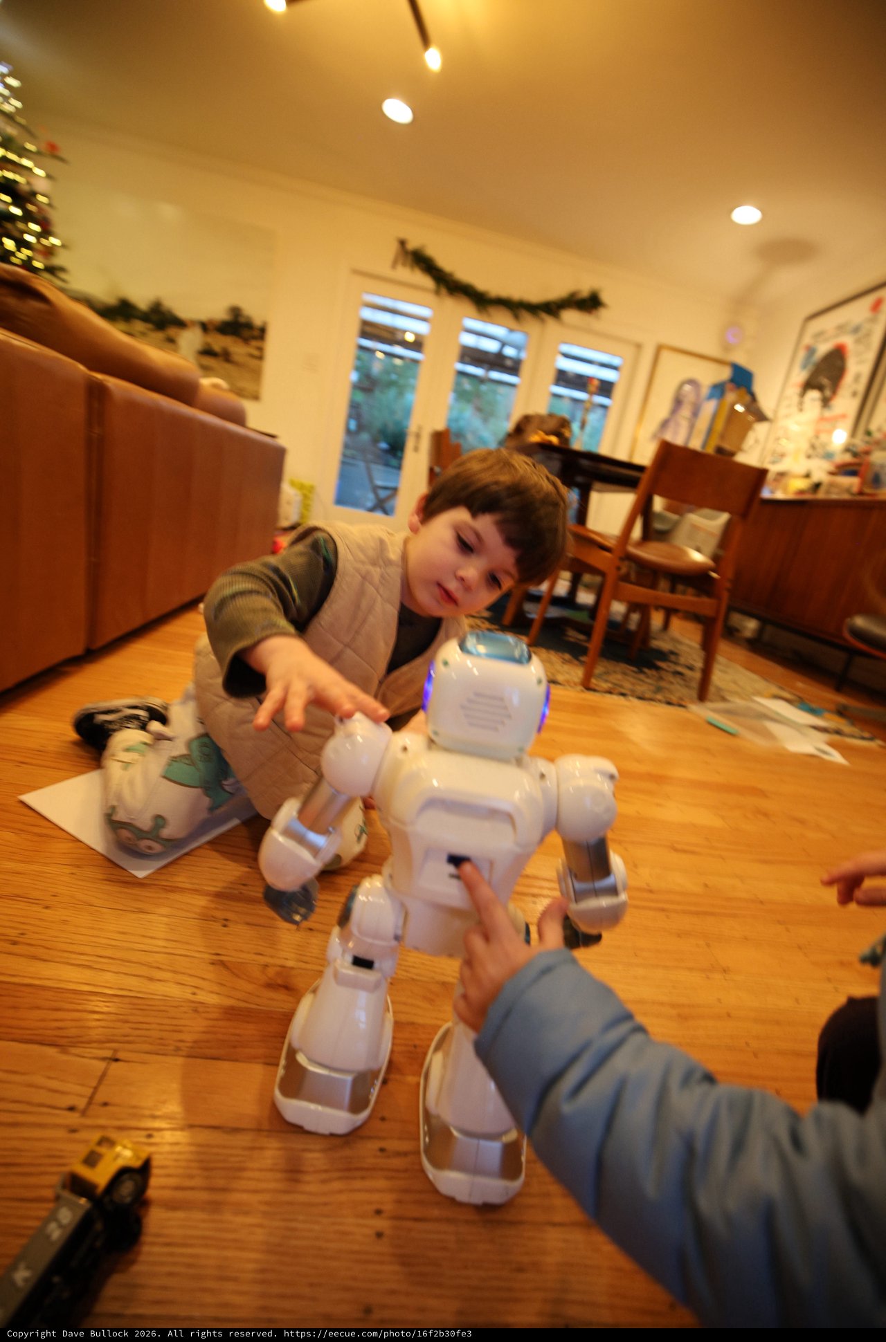 Child Playing with White Robotic Toy Dog at Home