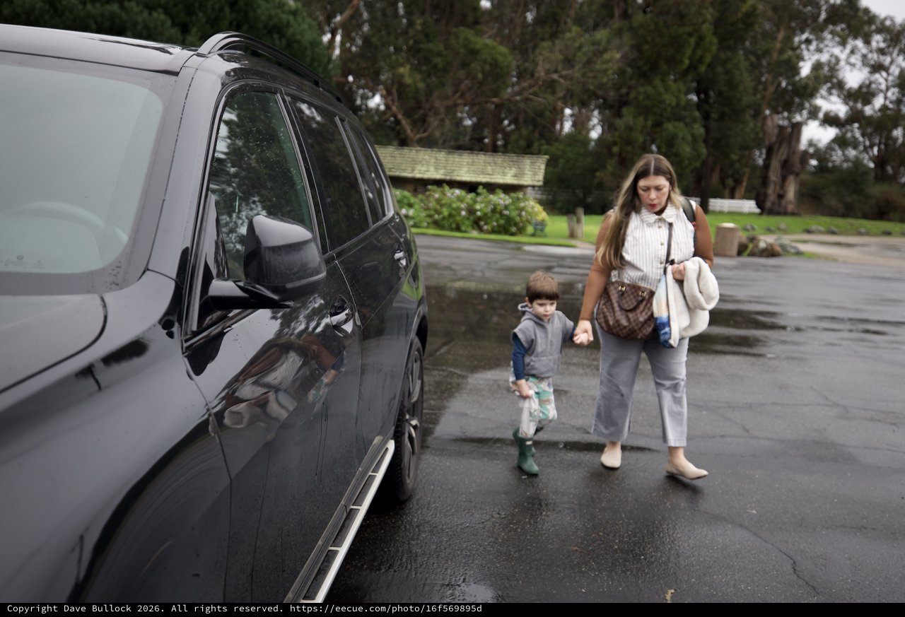 Mother and Child Walking to Car on Rainy Day