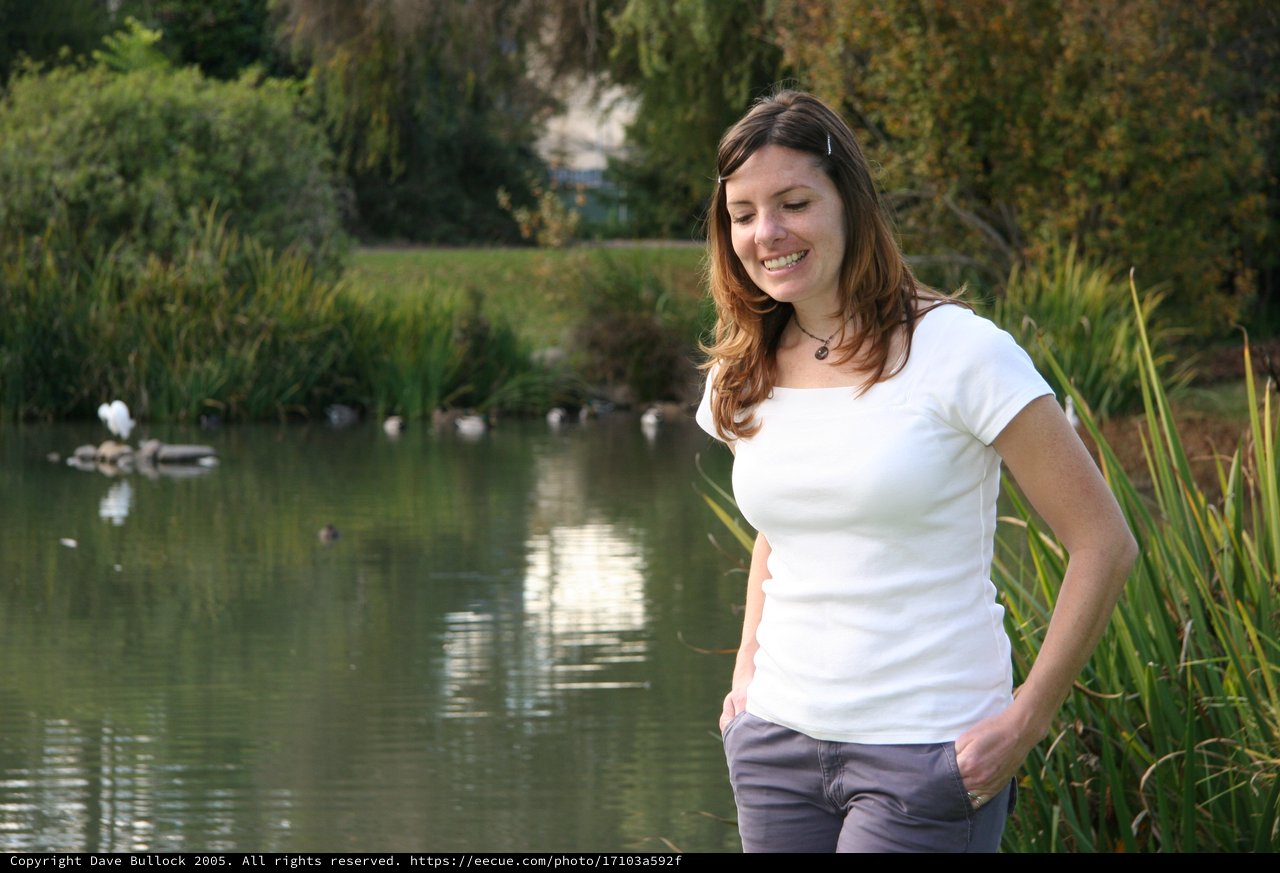 Smiling Woman by a Serene Park Pond
