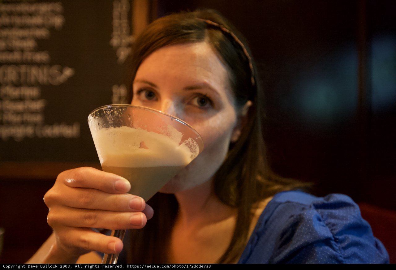 Woman Savoring a Frothy Cocktail at Bar