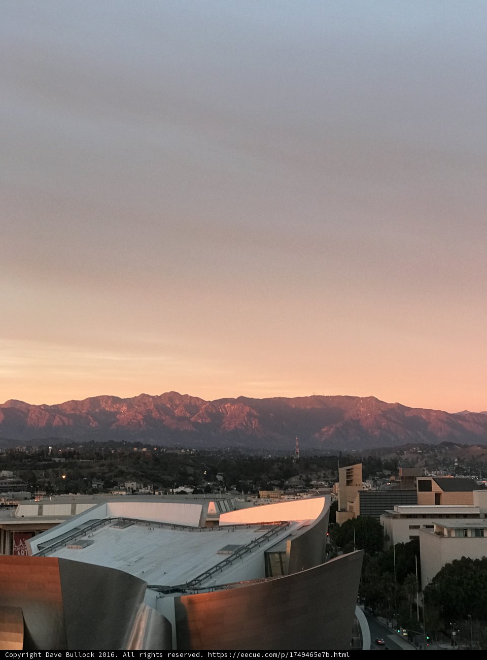 Sun setting over the urban mountains and buildings of LA