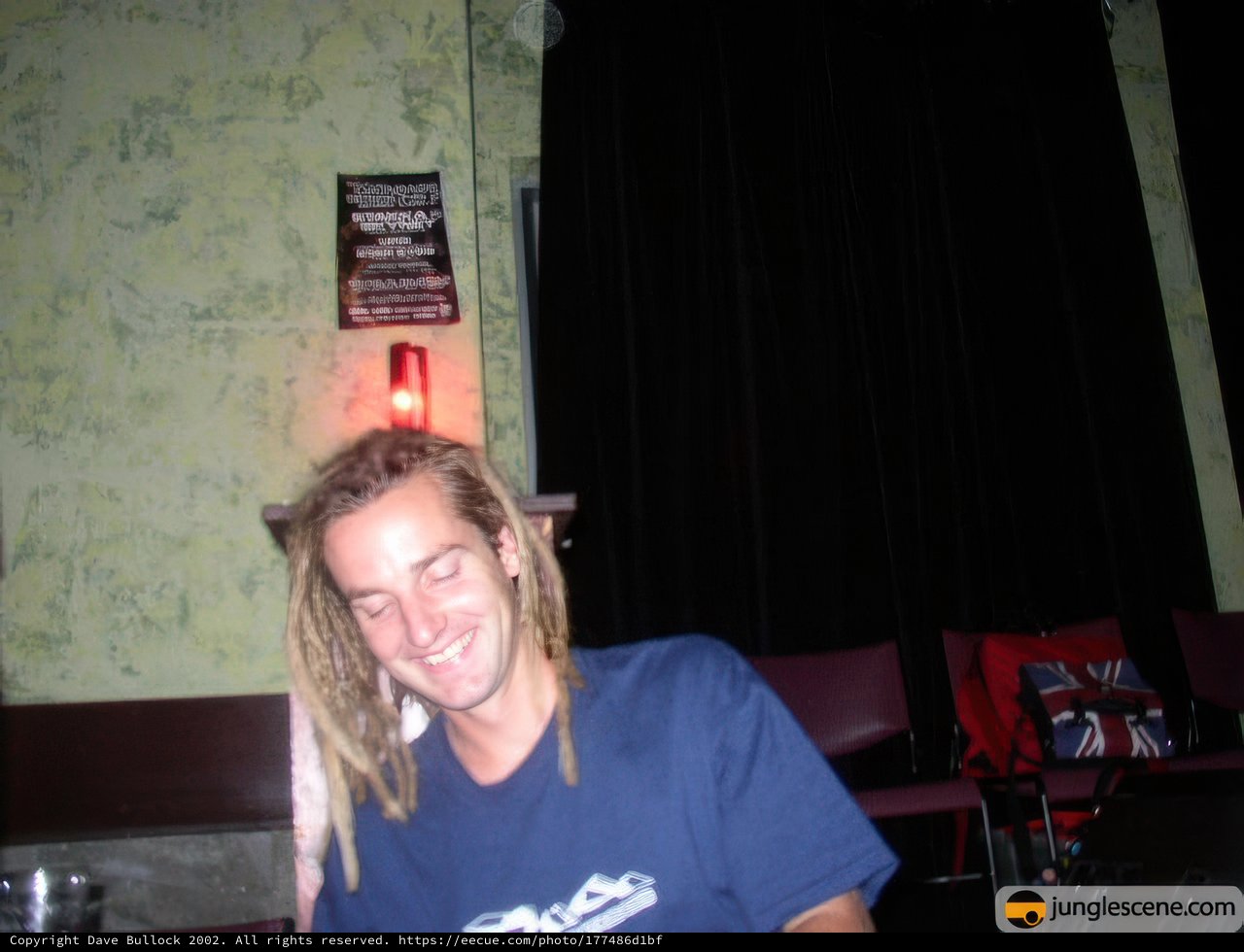 Dreadlocked man enjoying a drink at a local bar