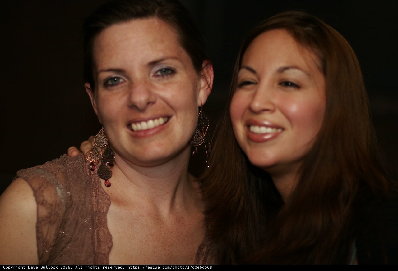 Two Women Smiling Together at Evening Event