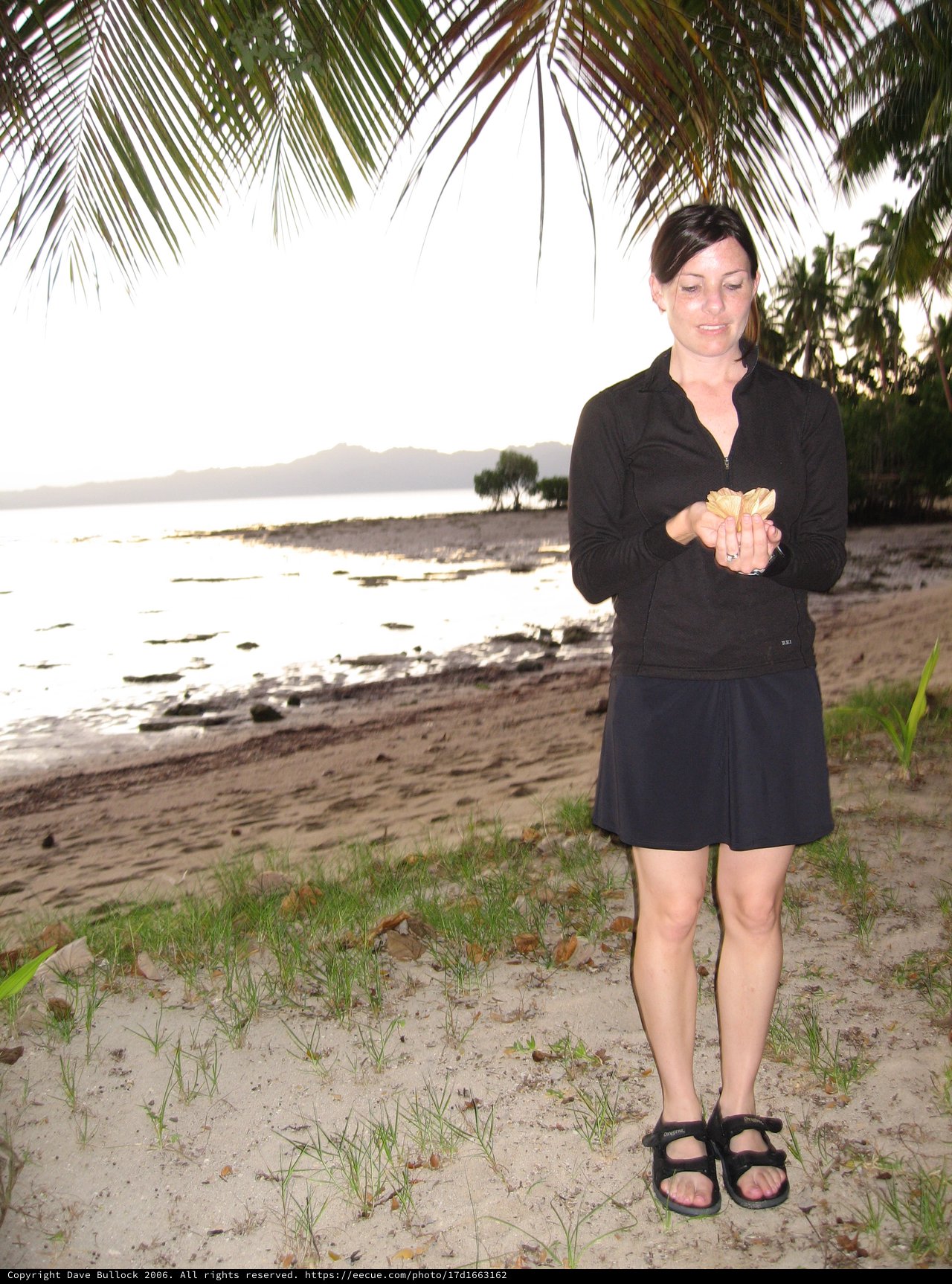 Woman Holds Shell at Twilight Fiji Beach