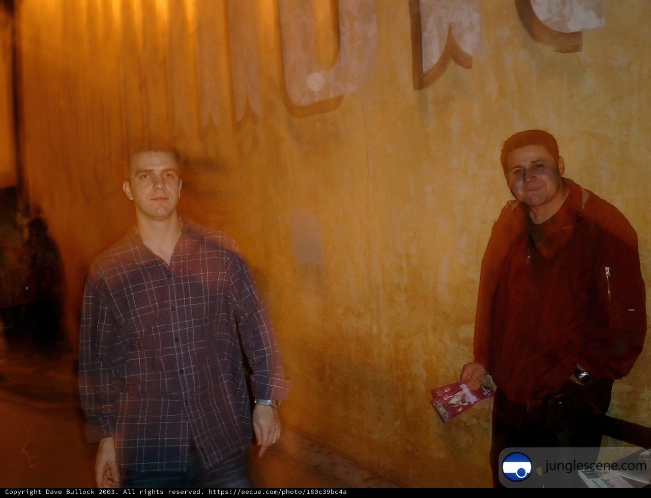 Two Men Posed for Portrait in Front of Urban Wall