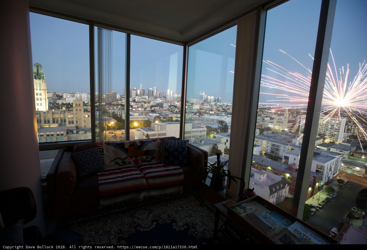 Fireworks illuminating the city sky from a penthouse window