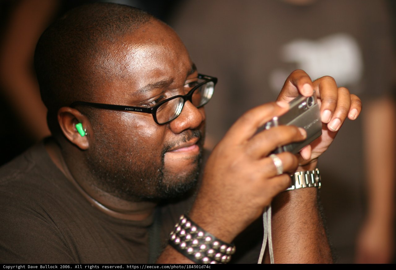 Brown Shirted Man with Glasses, Watch and Phone