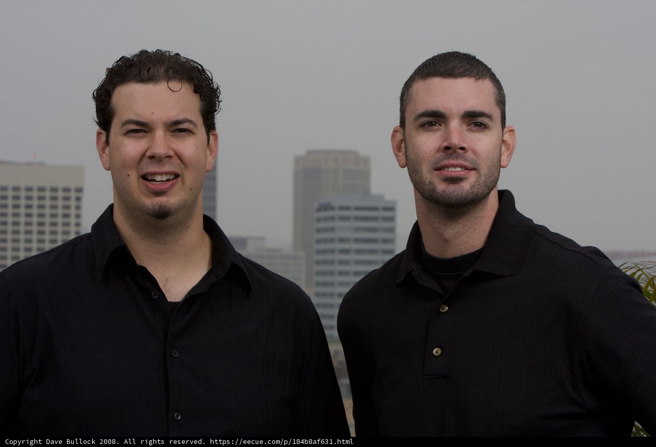 Two Happy Men Standing in Front of a Skyscraper