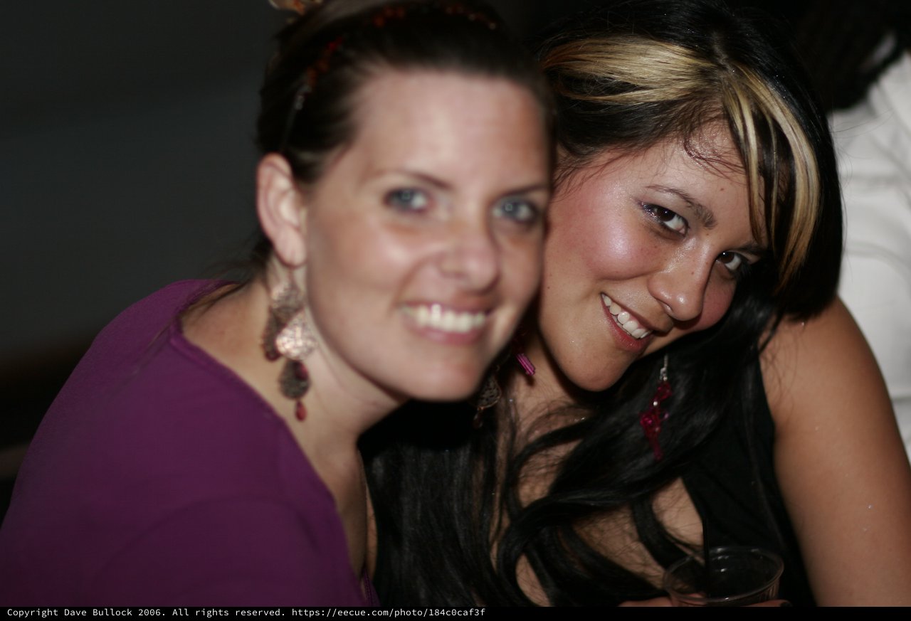 Two Smiling Women Posing Together at Night Event