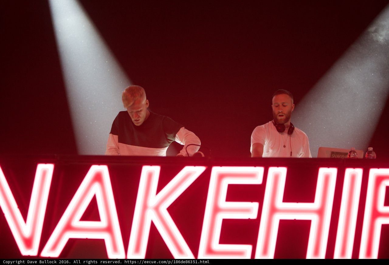 Two Men in front of Nakehip Neon Sign at Coachella