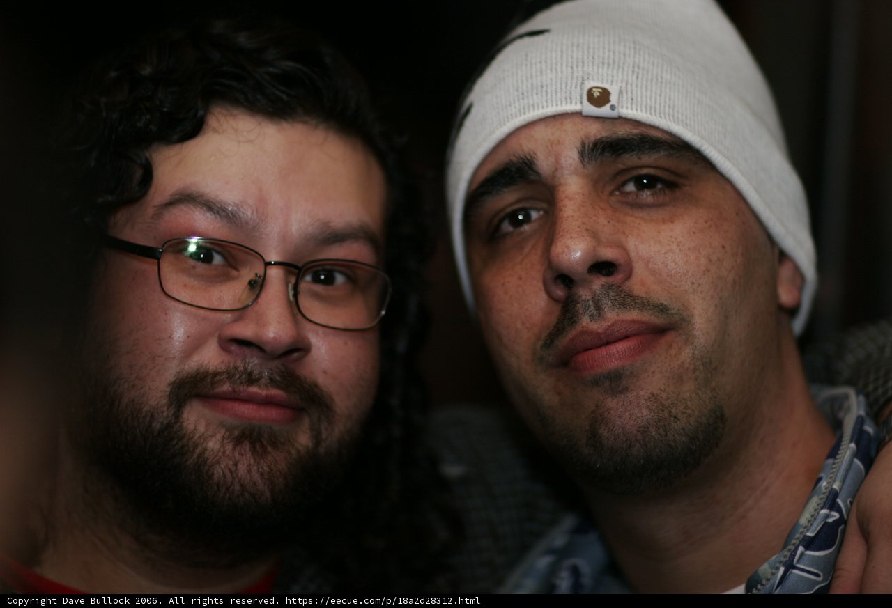 Two Men with Glasses and Hats Strike a Pose