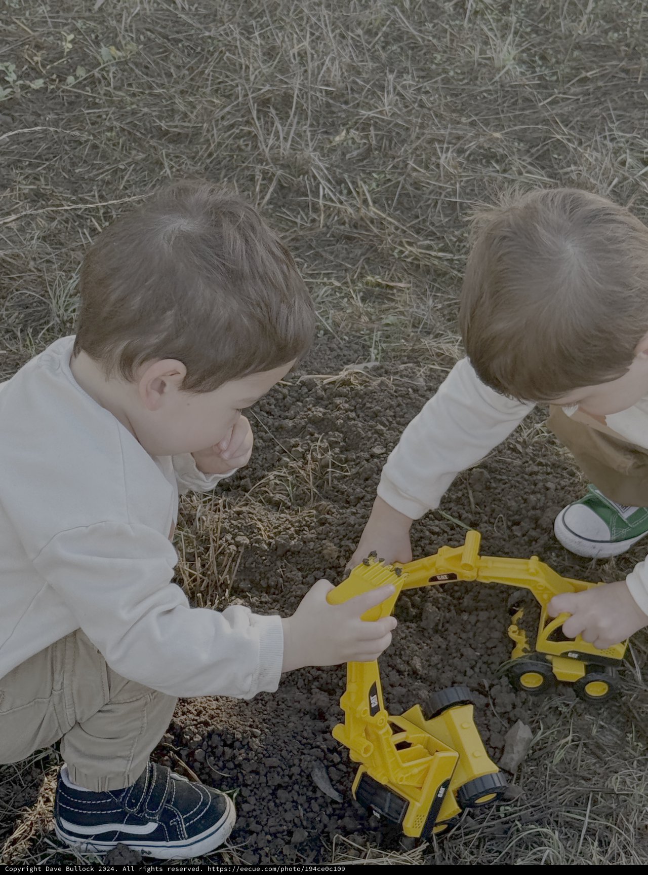 Two Children Playing with Yellow Toy Excavator