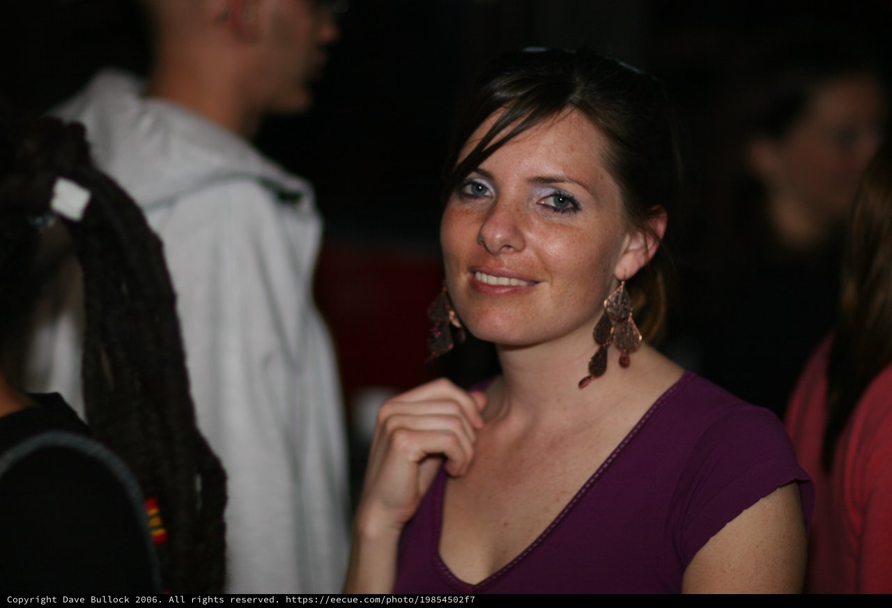 Smiling Woman at a Nighttime Social Gathering