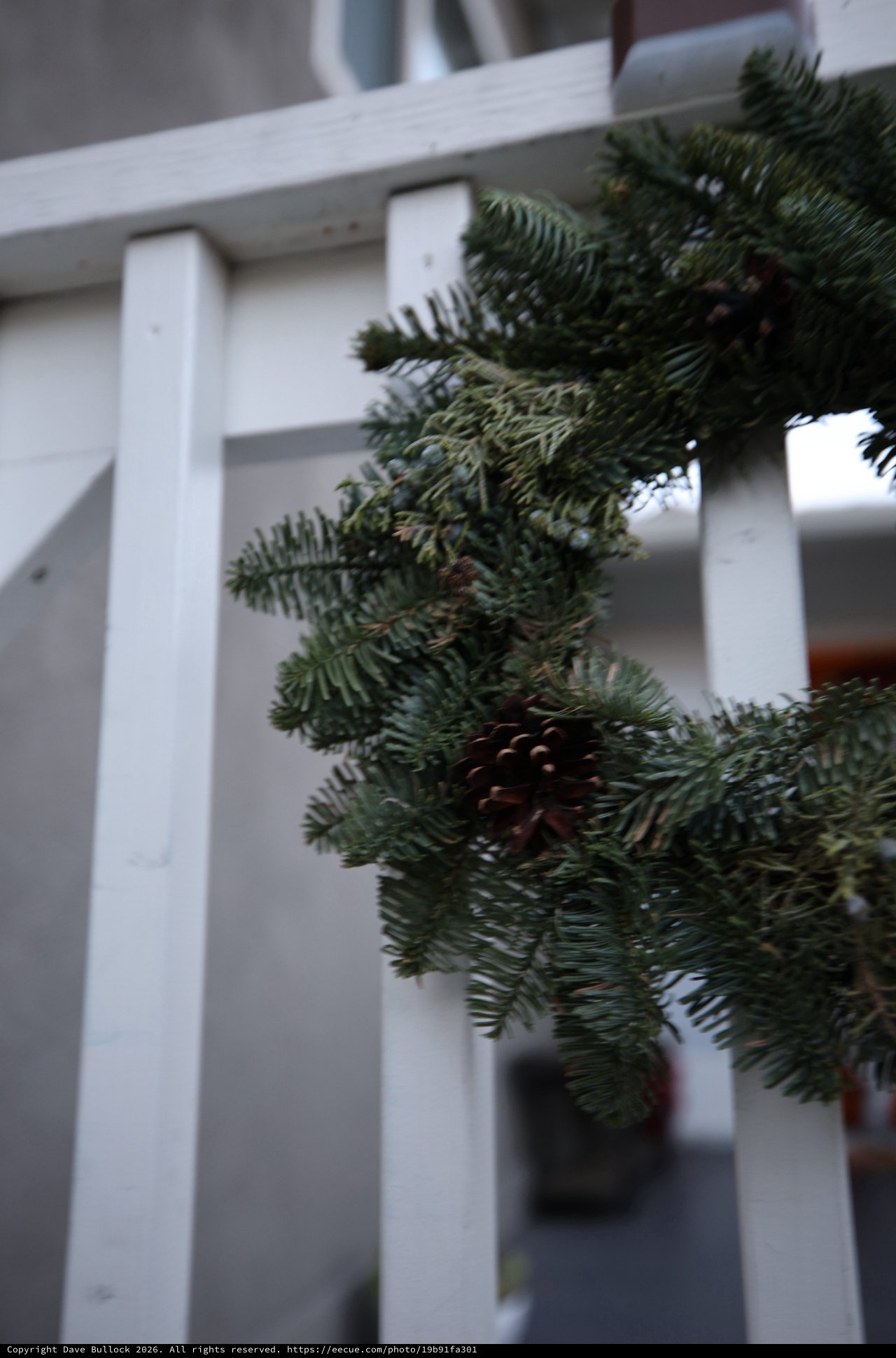 Evergreen Garland on White Porch Railing with Pine Cone