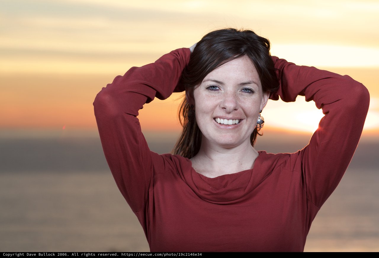 Radiant Woman Smiling at Golden Sunset Shore