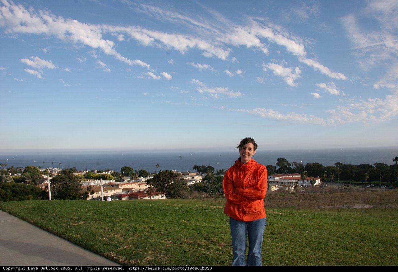 Woman Smiling on Hilltop Overlooking California Coastal Town