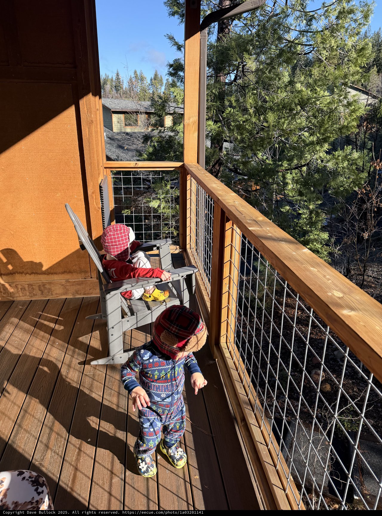 Toddlers Exploring a Snowy Mountain Cabin Deck