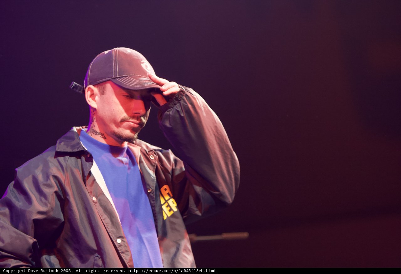 Man in Baseball Cap and Jacket Performing on Stage
