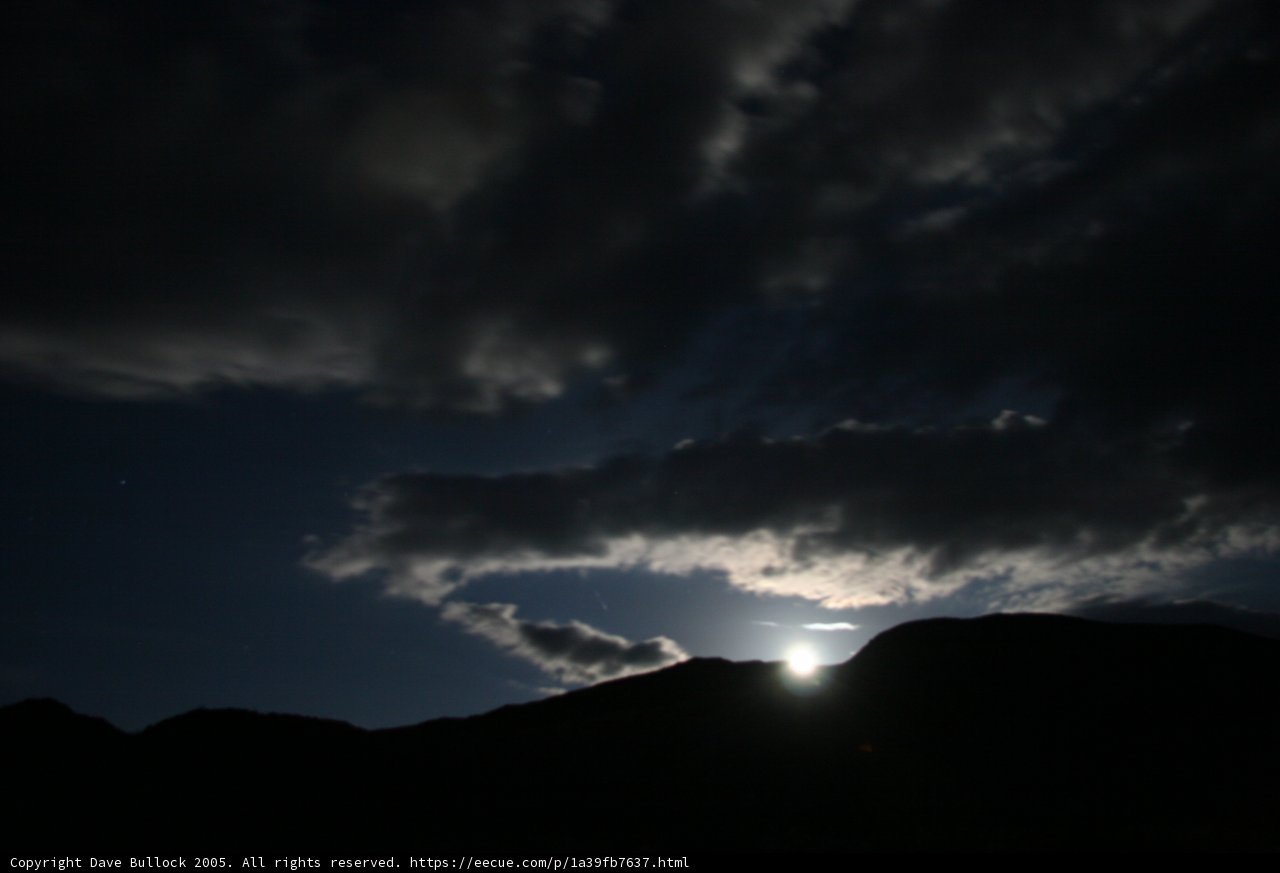 Lunar Glimpse Behind the Cumulus Clouds