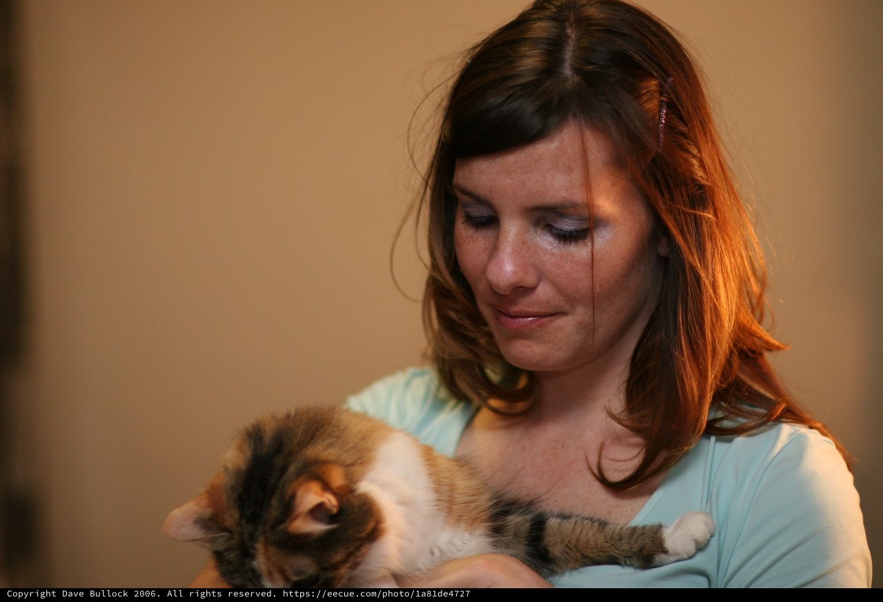 Tender Moment: Woman Cradling Sleeping Kitten
