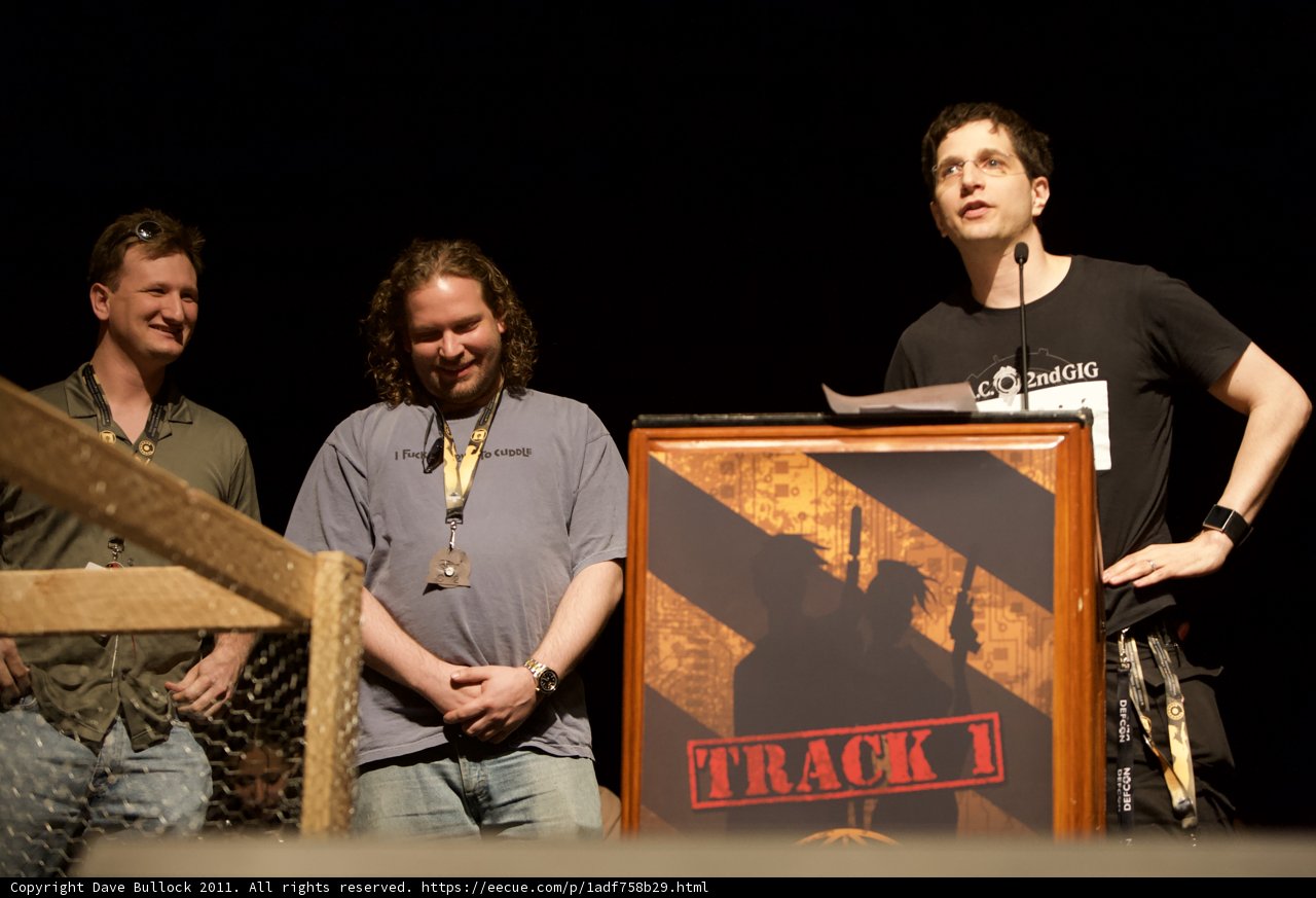 Three men behind podium with microphone