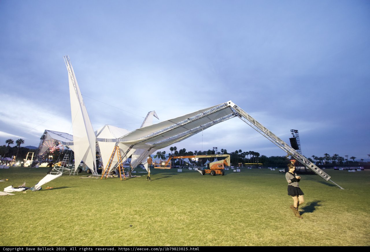 Woman standing near a large tent in the grass