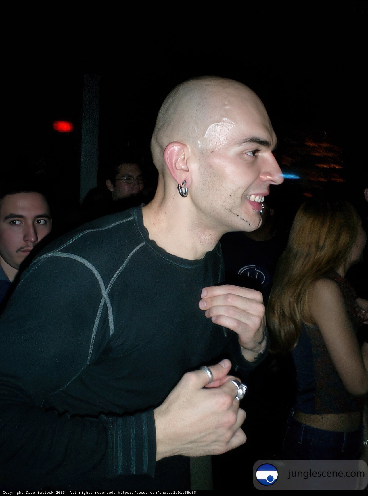 Tattooed Bald Man Performing with Microphone
