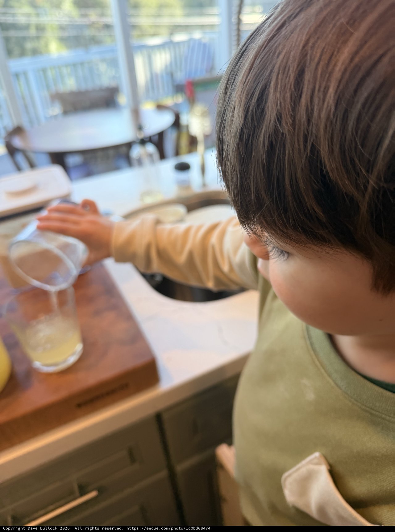 Young Child Drawing and Drinking at Home Table