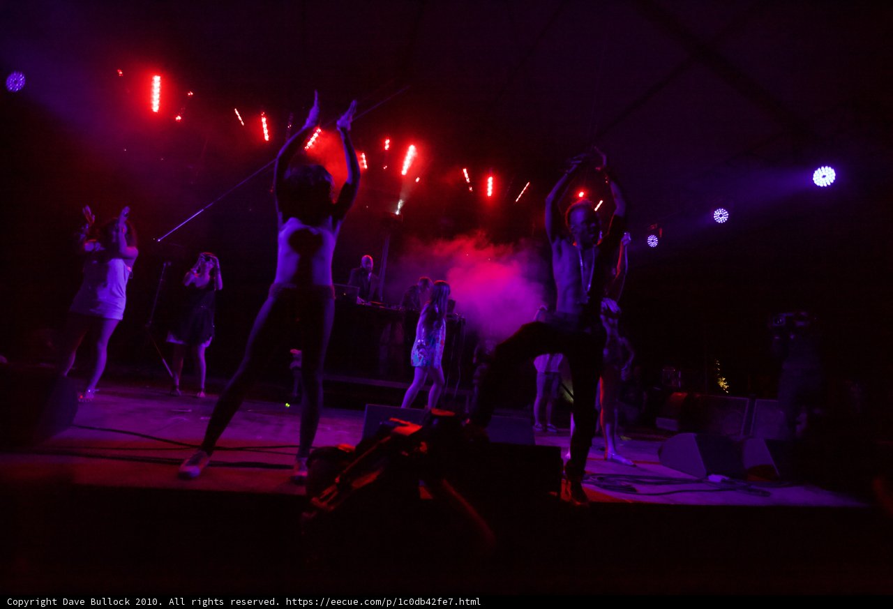 Red-Lit Concert Performance with Crowd and Stage Spotlight