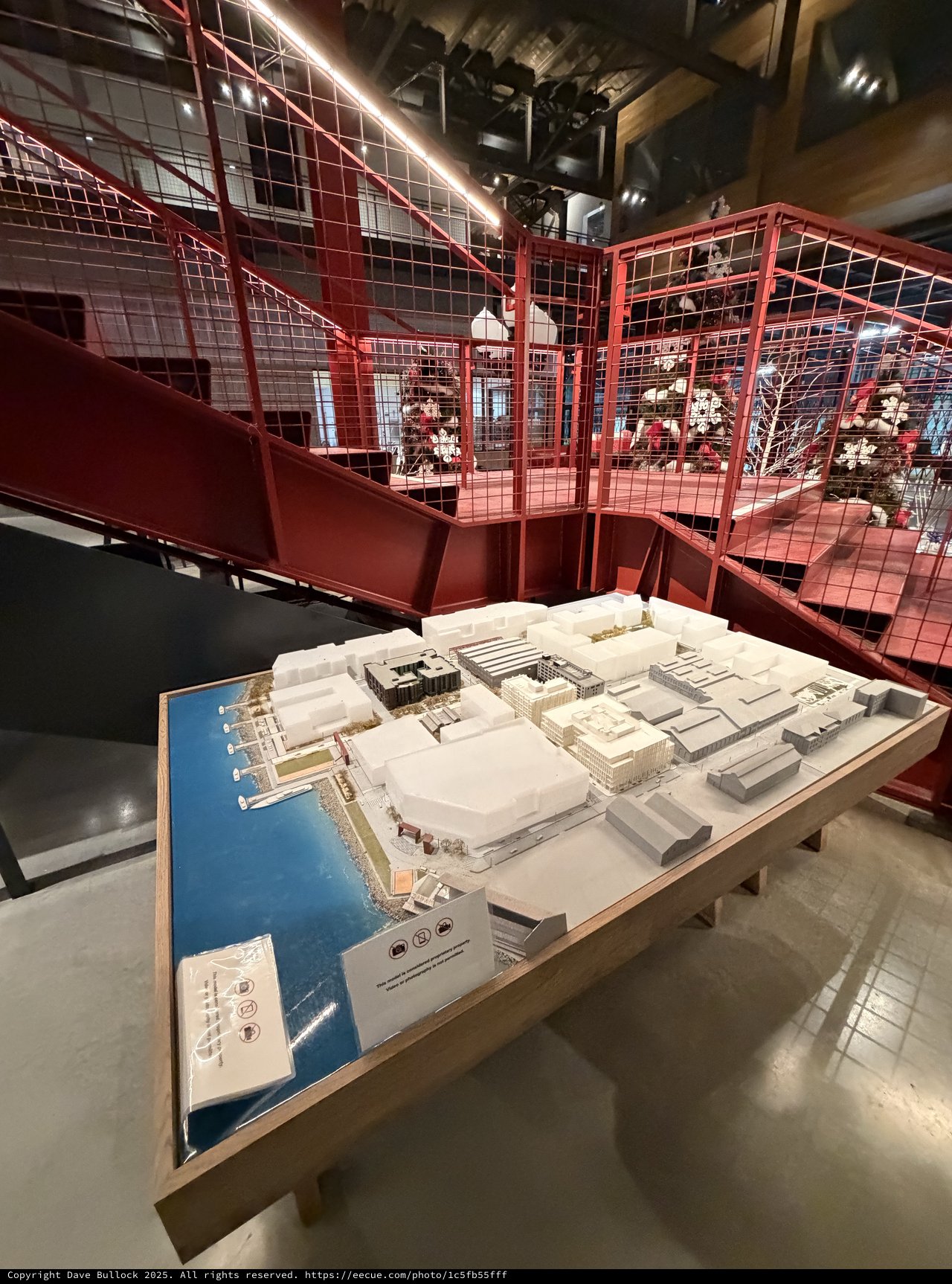 Architectural Model Display in Red Industrial Gallery Space