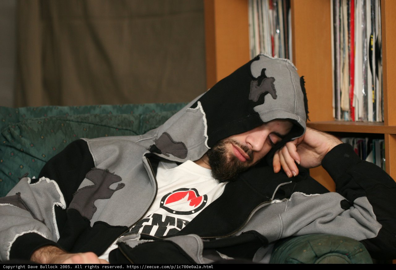 Hoodie-clad Man Lounging by Bookshelf