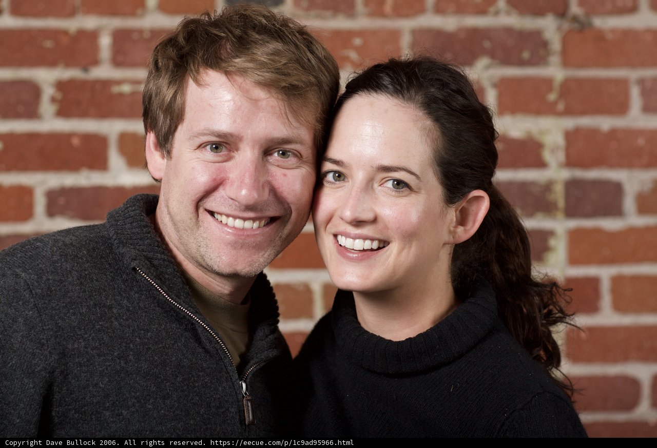 Smiling Couple Against Brick Wall