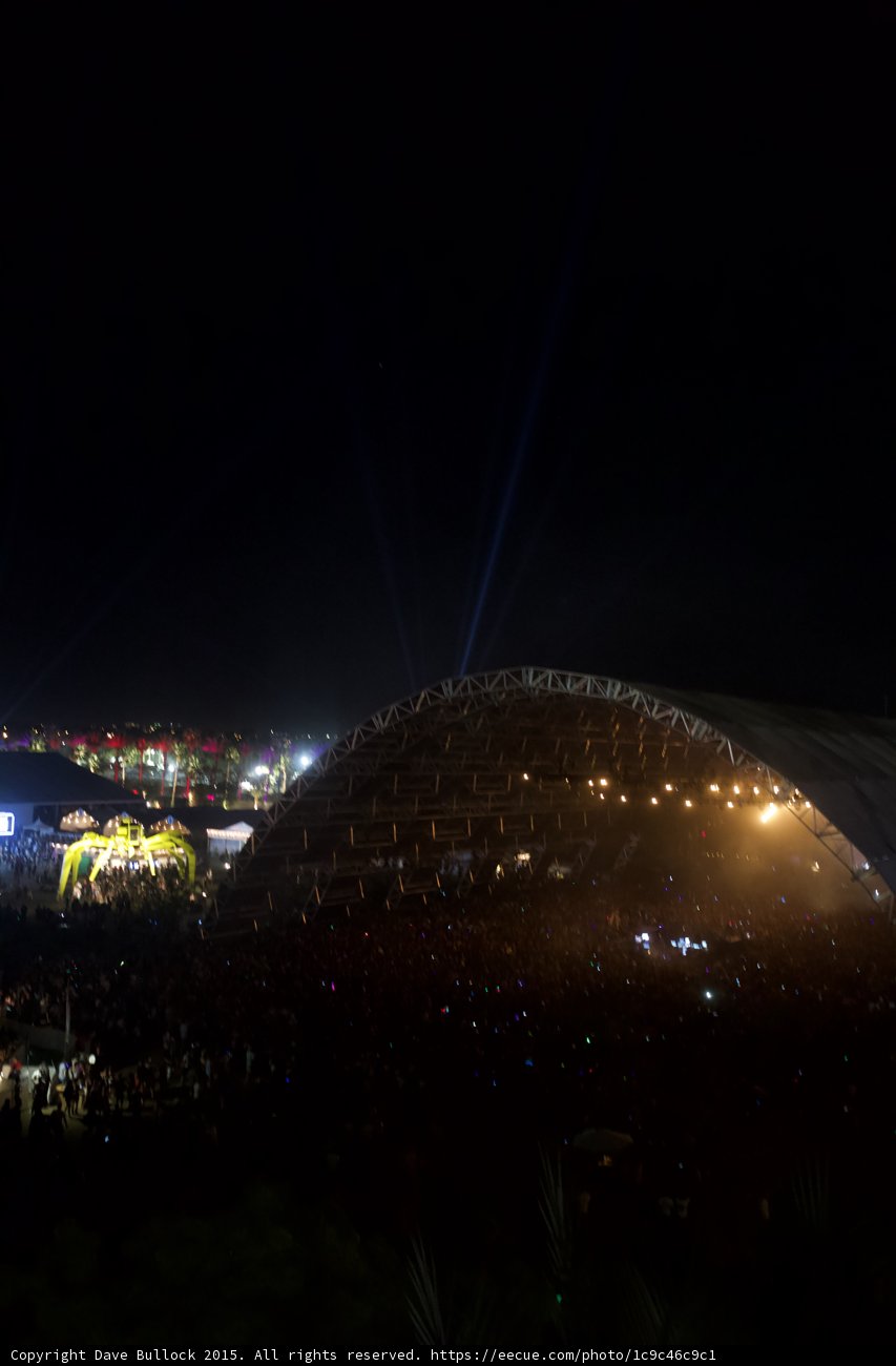 Metropolis Lights Up the Night Sky Caption: The Architectural Marvel of Coachella's Stadium Dominates the Urban Skyline at Night, Illuminating the Crowd with Stunning Lighting Effects.